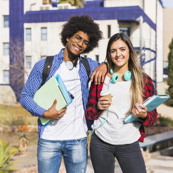casal-de-raca-mista-feliz-posando-em-frente-ao-predio-da-universidade